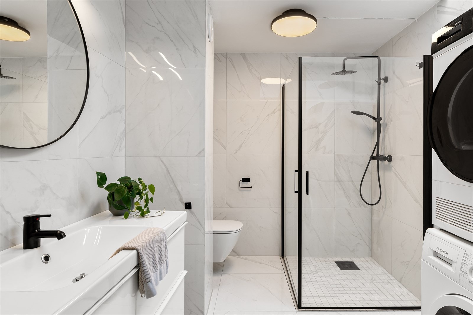 Lekkert flislagt bad. Innredet med dusjnisje, vask i seksjon, toalett og opplegg for vaskemaskin og tørketrommel. Galleribilde