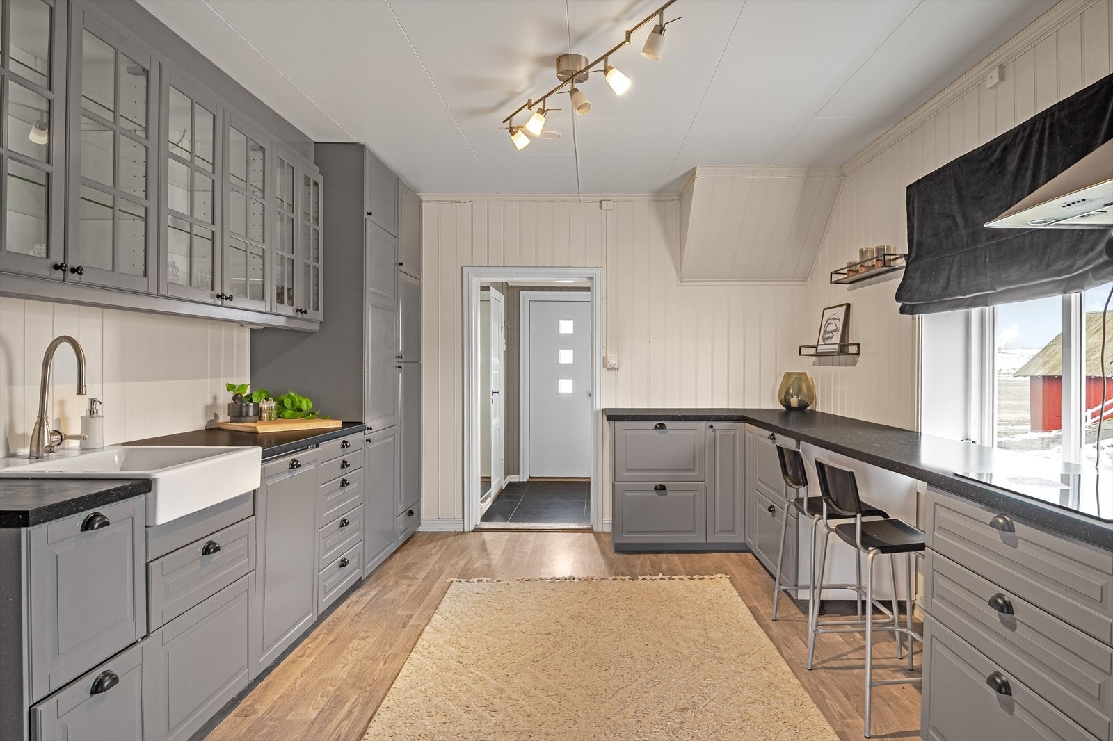 Romslig og lyst kjøkken med innredning fra 2017. Innredningen har profilerte fronter og overskap med glass. Galleribilde