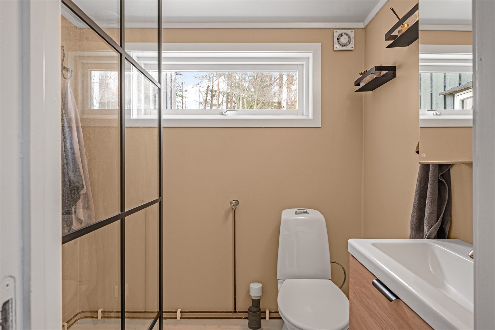 Overflatene på badet er pusset opp etter 2019. Her er det baderomsplater på veggene og belegg på gulvet med varmekabler. Galleribilde