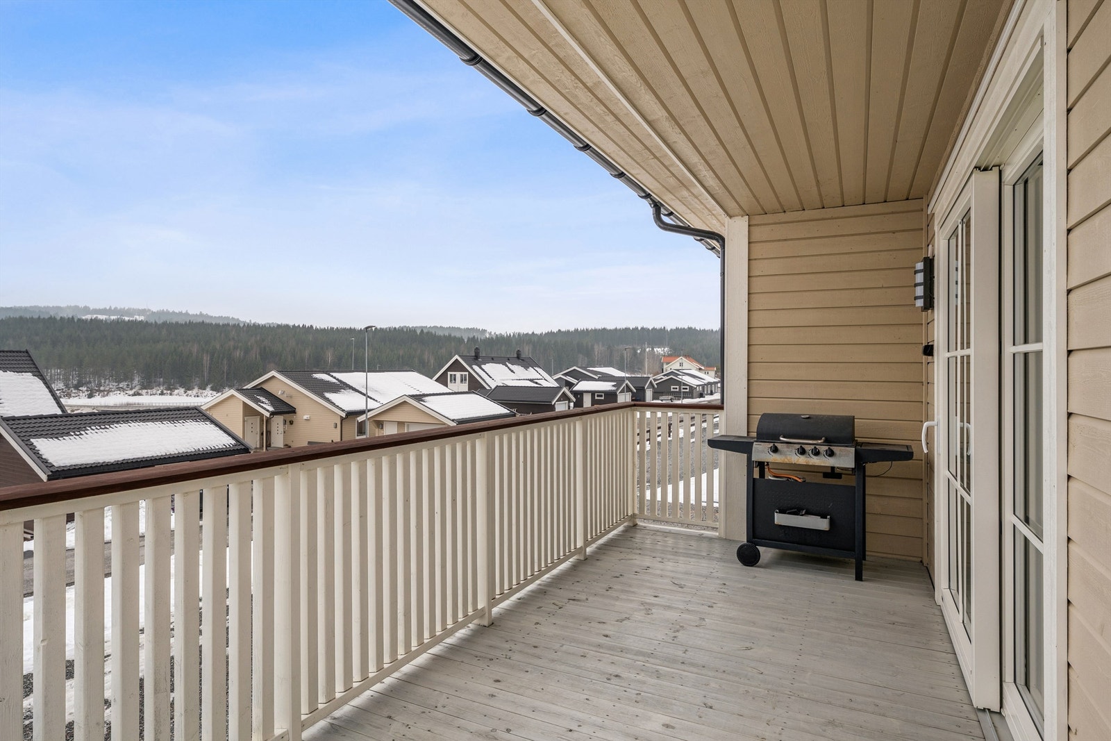 Romslig veranda som strekker seg i vinkel rundt boligen. Galleribilde