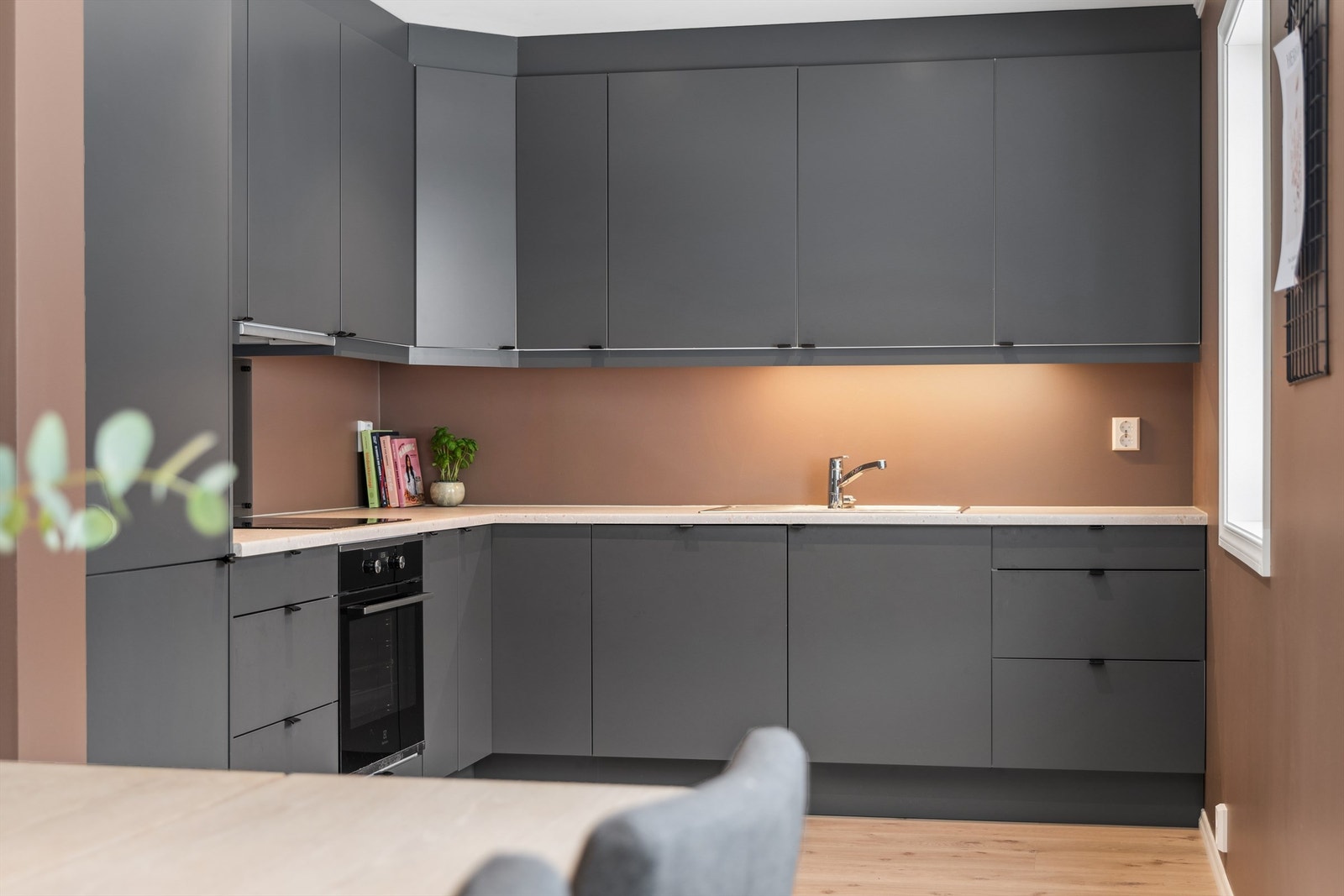 Kjøkkenet har moderne innredning fra byggeår med glatte fronter, laminert benkeplate og integrerte hvitevarer som stekeovn, platetopp, oppvaskmaskin og kjøleskap med fryser. Galleribilde