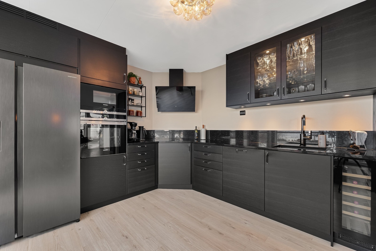 Kjøkkenet har integrerte hvitevarer i form av oppvaskmaskin, ovn, mikro, vinskap og platetopp. Galleribilde