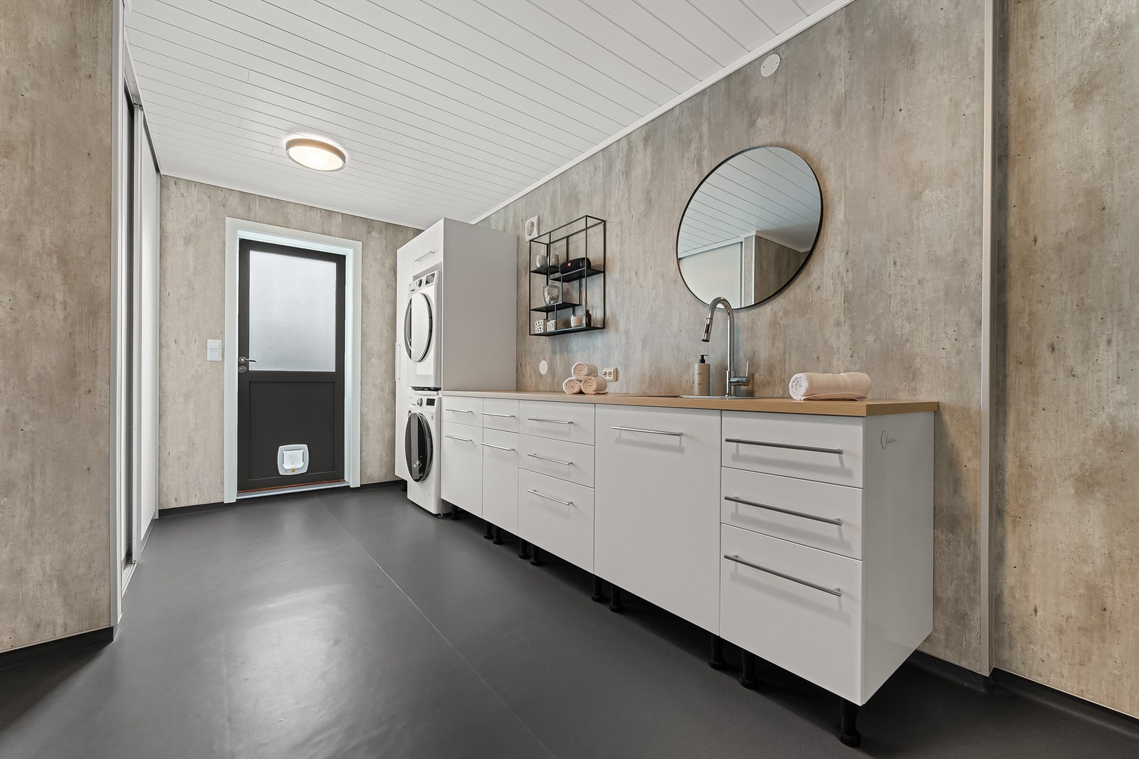 Bad/Vaskerom med lys innredning, toalett, badekar og opplegg for vaskemaskin. Galleribilde