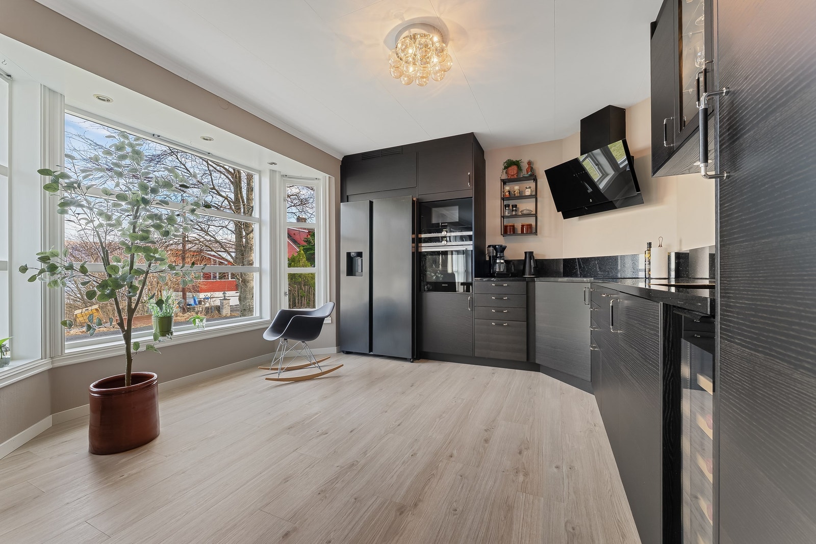 Kjøkkenet har mørk innredning i glatte fronter med benkeplate av stein. Galleribilde