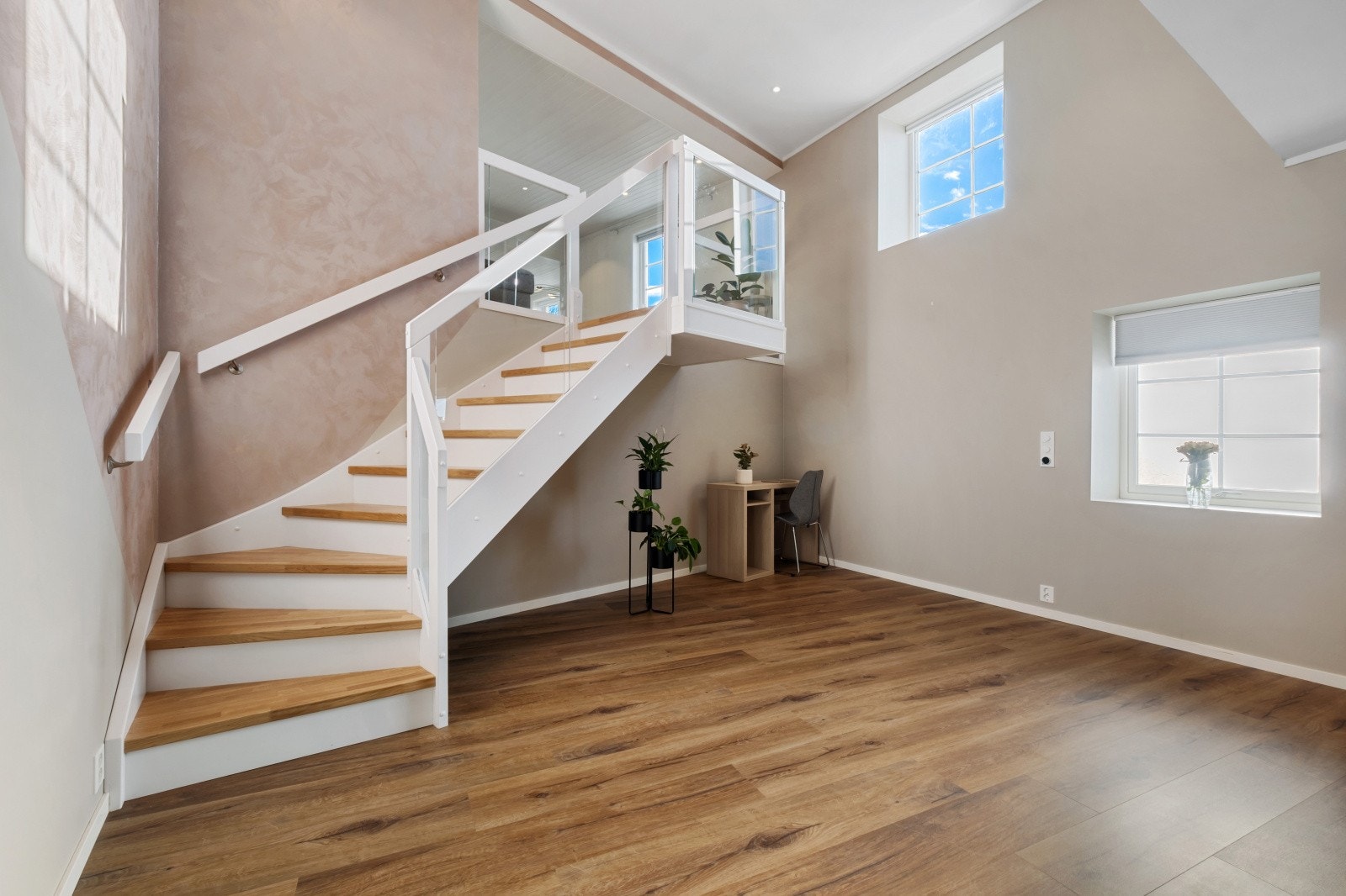 Rommet er lyst og moderne, med fine overflater i lyse, duse toner som sammen med god takhøyde skaper en luftig og behagelig atmosfære, perfekt for avslapning og hyggelige stunder med familien Galleribilde