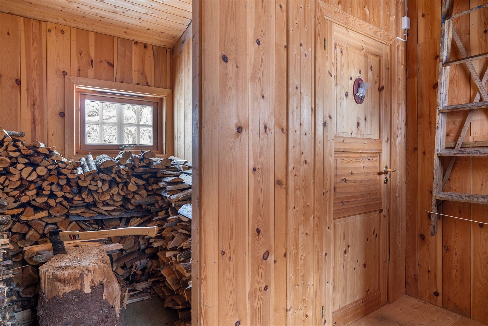 Vedskåle og inngang til utedo i uthuset Galleribilde