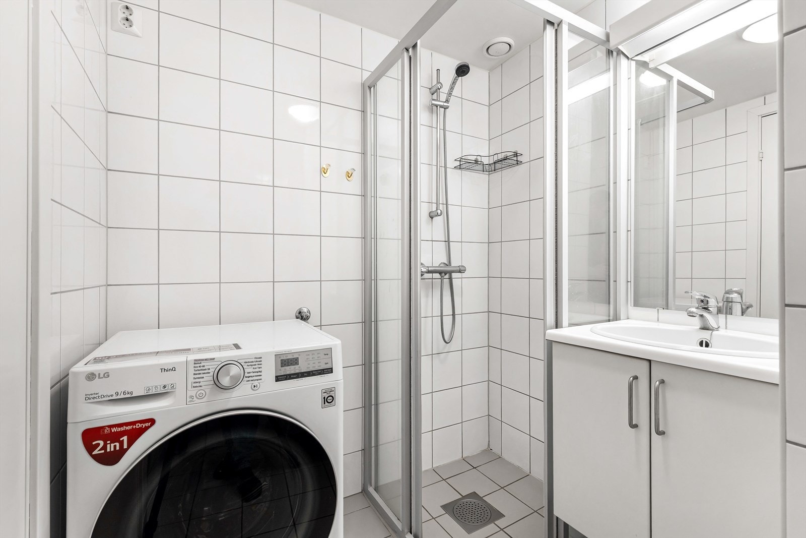 Lyst, flislagt bad med varmekabler, mekanisk avtrekk og opplegg for vaskemaskin. Galleribilde