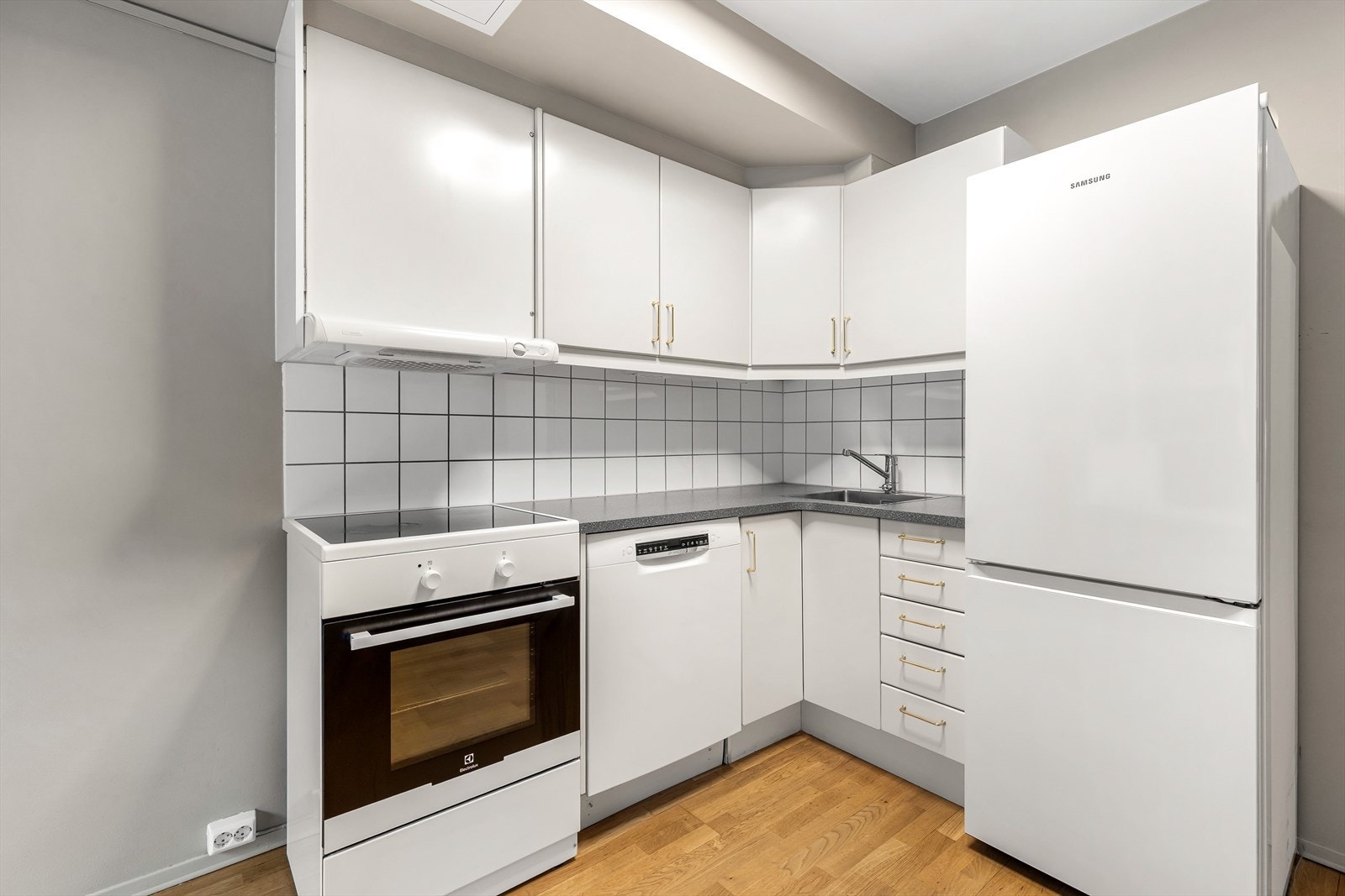 Innredningen har slette fronter, laminat benkeplate og plass til hvitevarer. Galleribilde