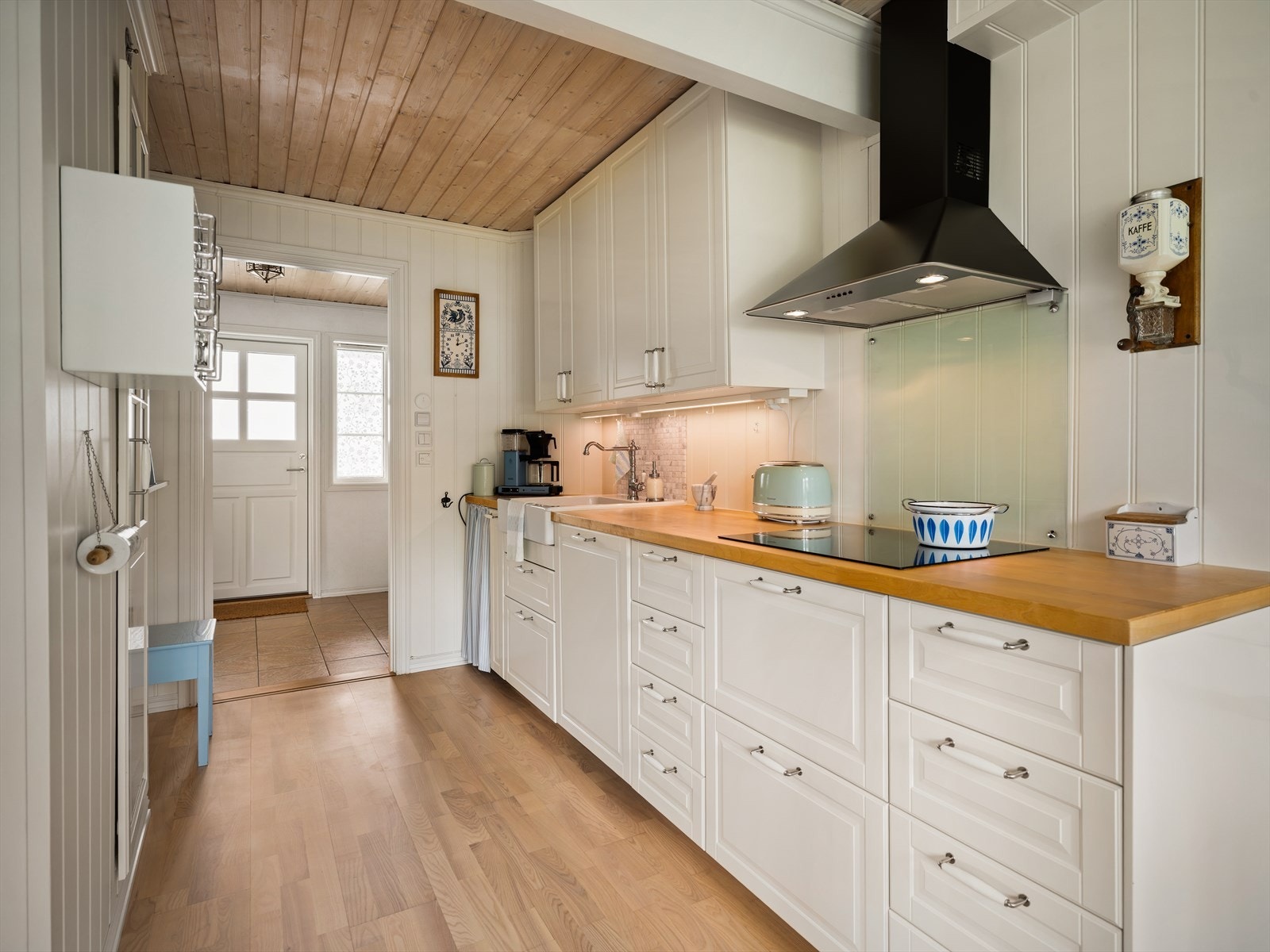 Innredningen er klassisk med hvite profilerte fronter, heltre benkeplate og flislagt sprutsone. Galleribilde