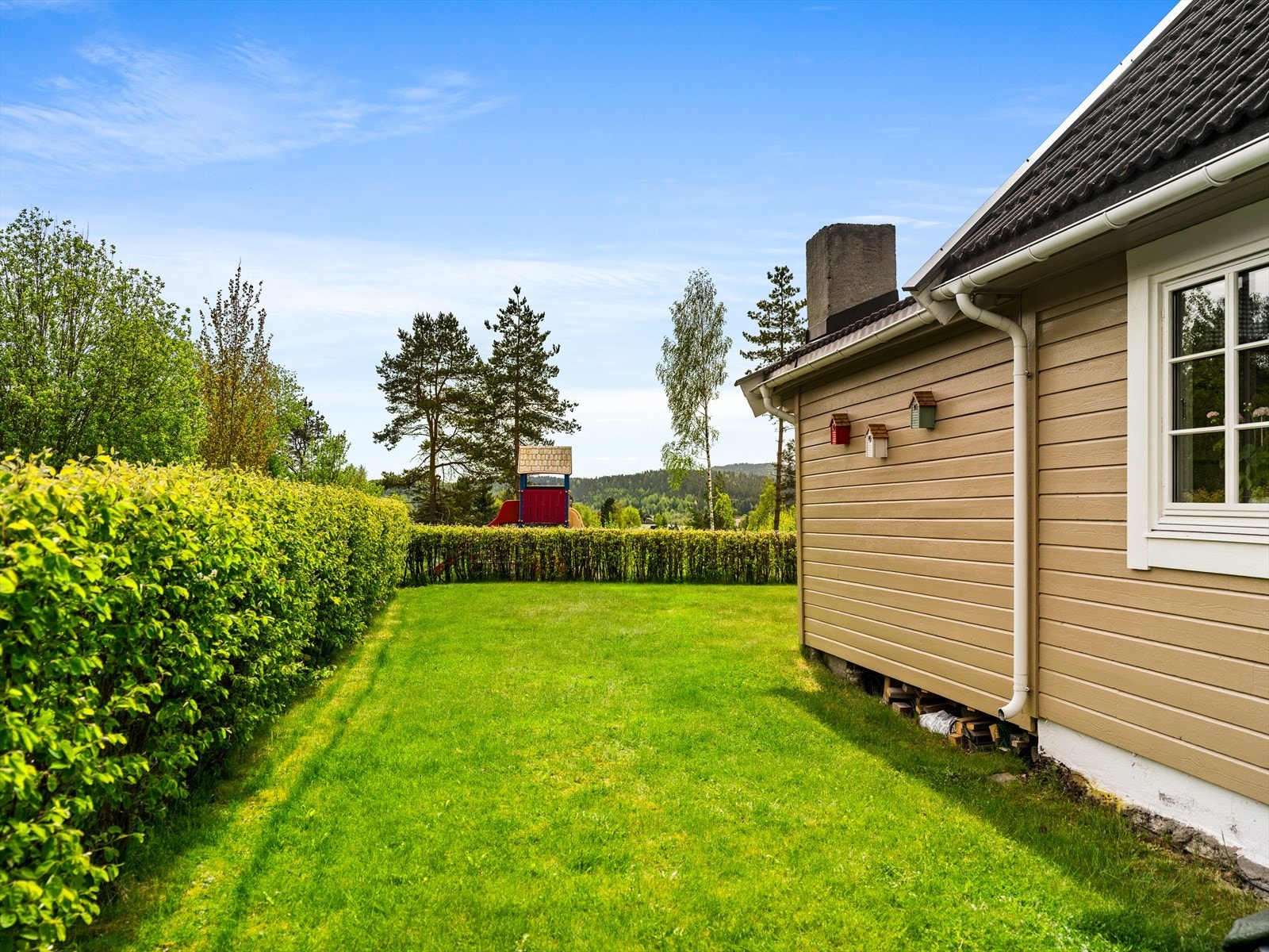 Tomten er pent avgrenset med hekk. Galleribilde