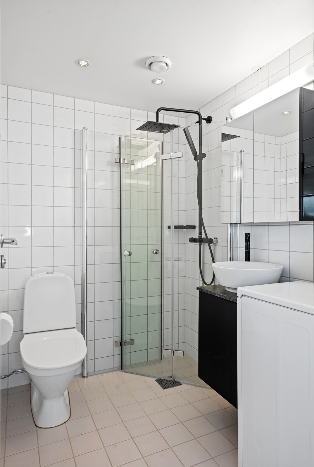 Flislagt bad med dusjhjørne og praktisk opplegg for vaskemaskin. Galleribilde