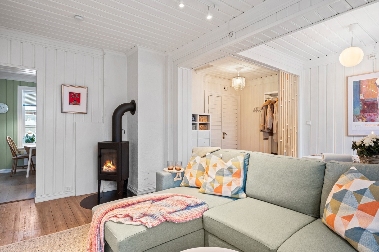 Leiligheten har en åpen stue- og spisestueløsning med en vedovn som gir god varme. Galleribilde