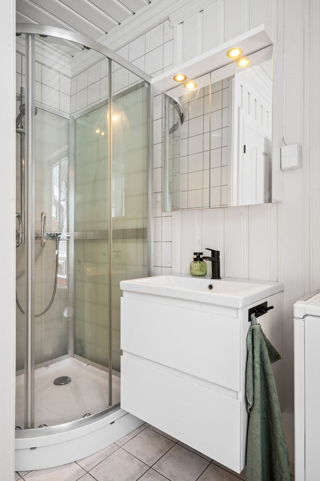 Badet er utstyrt med et praktisk dusjkabinett og speilskap med belysning. Galleribilde