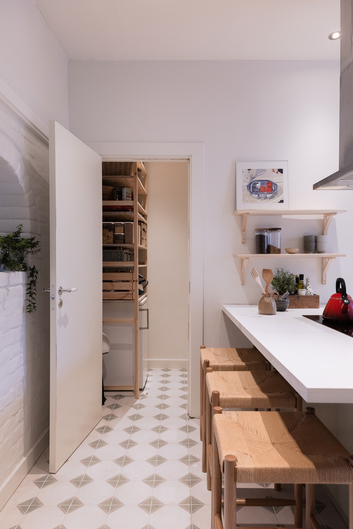 Det er plass til barstoler ved kjøkkenøyen. Den buede nisjen i veggen er et blikkfang på kjøkkenet. Galleribilde