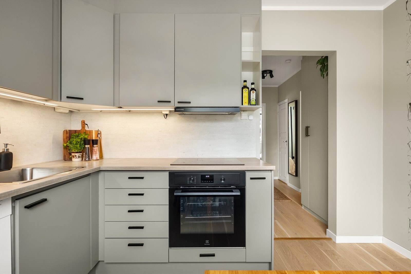 Benkeplaten er i slitesterk laminat, og det er integrerte hvitevarer med induksjonstopp og stekeovn. Galleribilde