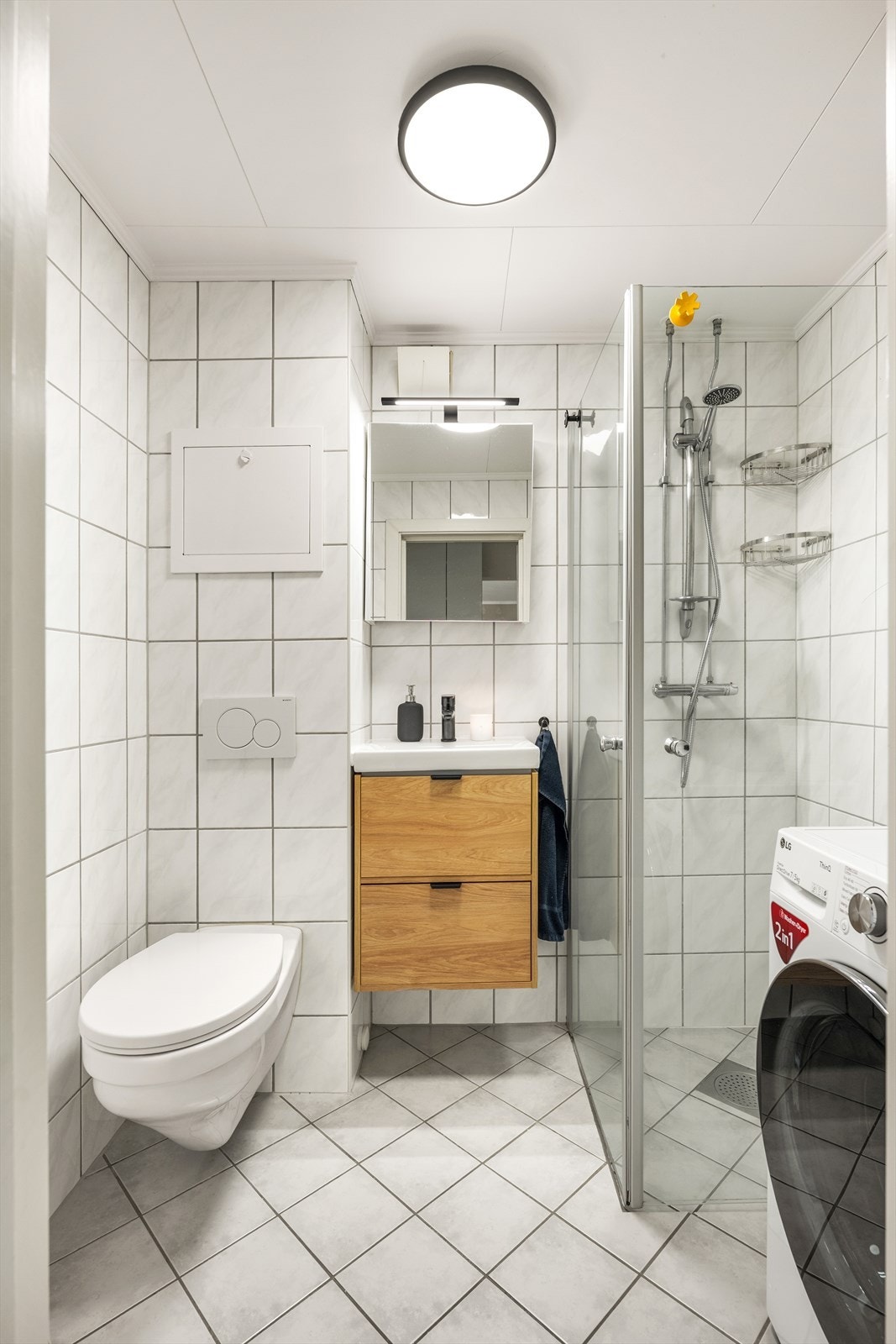 Badet har innredning med nedfelt servant, veggmontert toalett og dusjvegger/hjørne. Opplegg til vaskemaskin. Galleribilde