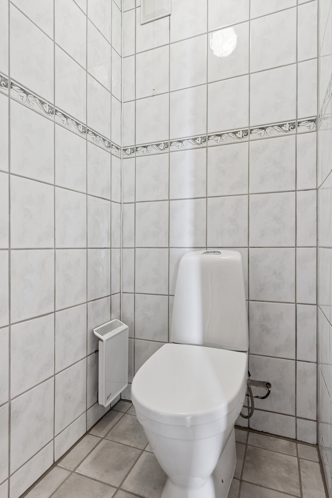 Praktisk toalettrom i underetasjen med fliser på gulv og vegger. Galleribilde