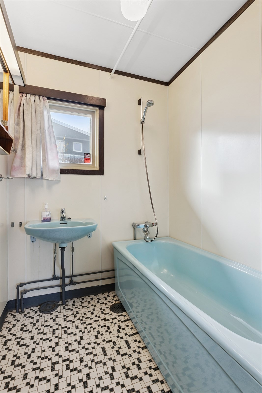 Badet i første etasje er innredet med badekar og veggmontert servant. Galleribilde