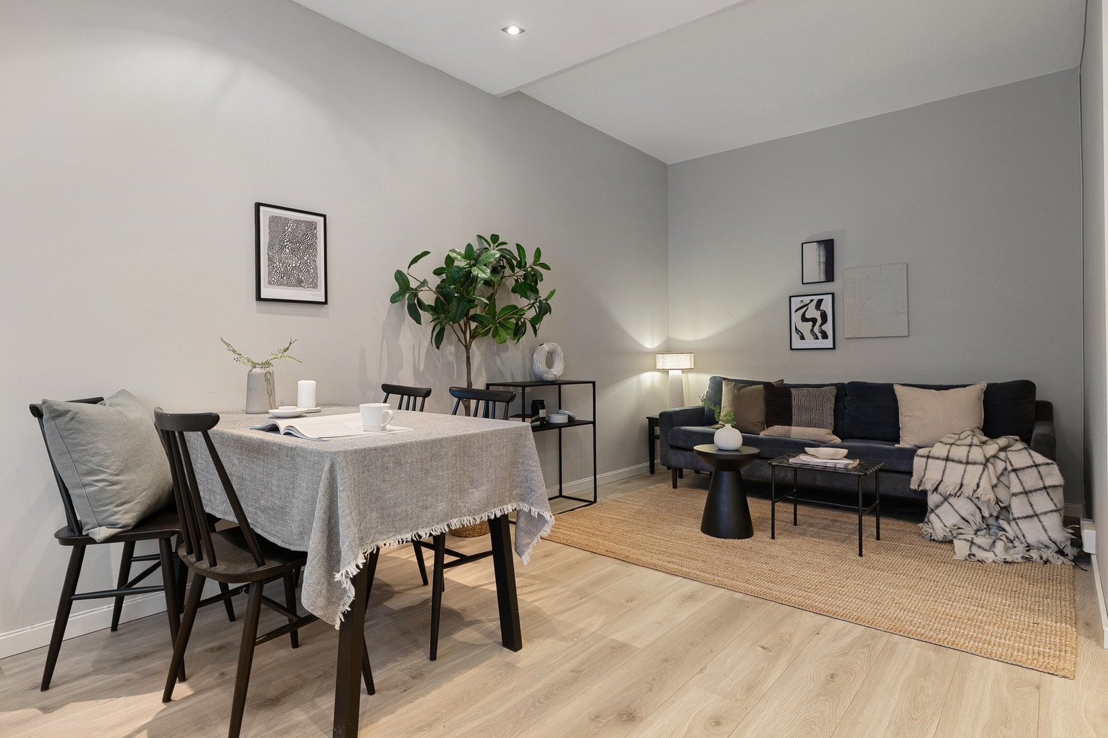 Romslig stue med naturlig inndeling mellom spise- og sofasonen. Galleribilde