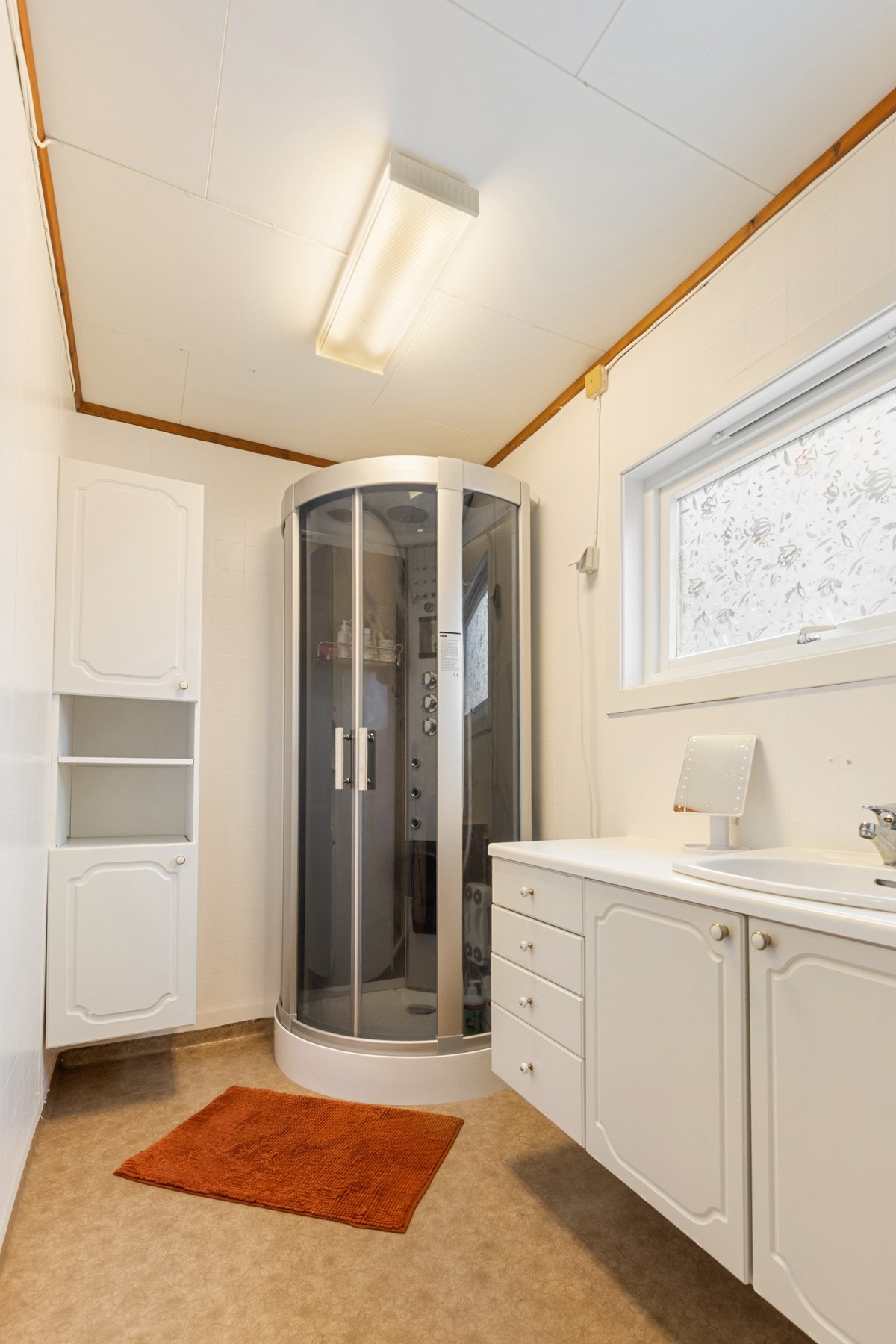 Badet er innredet med dusjkabinett fra 2021, wc, innredning med servant og opplegg for vaskemaskin. Galleribilde