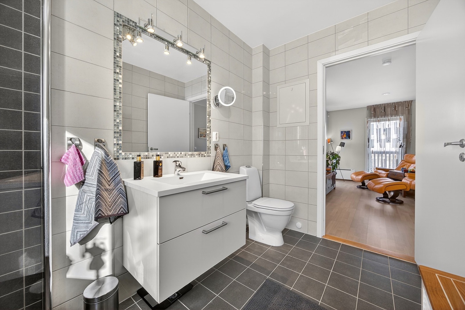 Rommet er innredet med vegghengt servantskap, speil med belysning og gulvstående toalett. Galleribilde