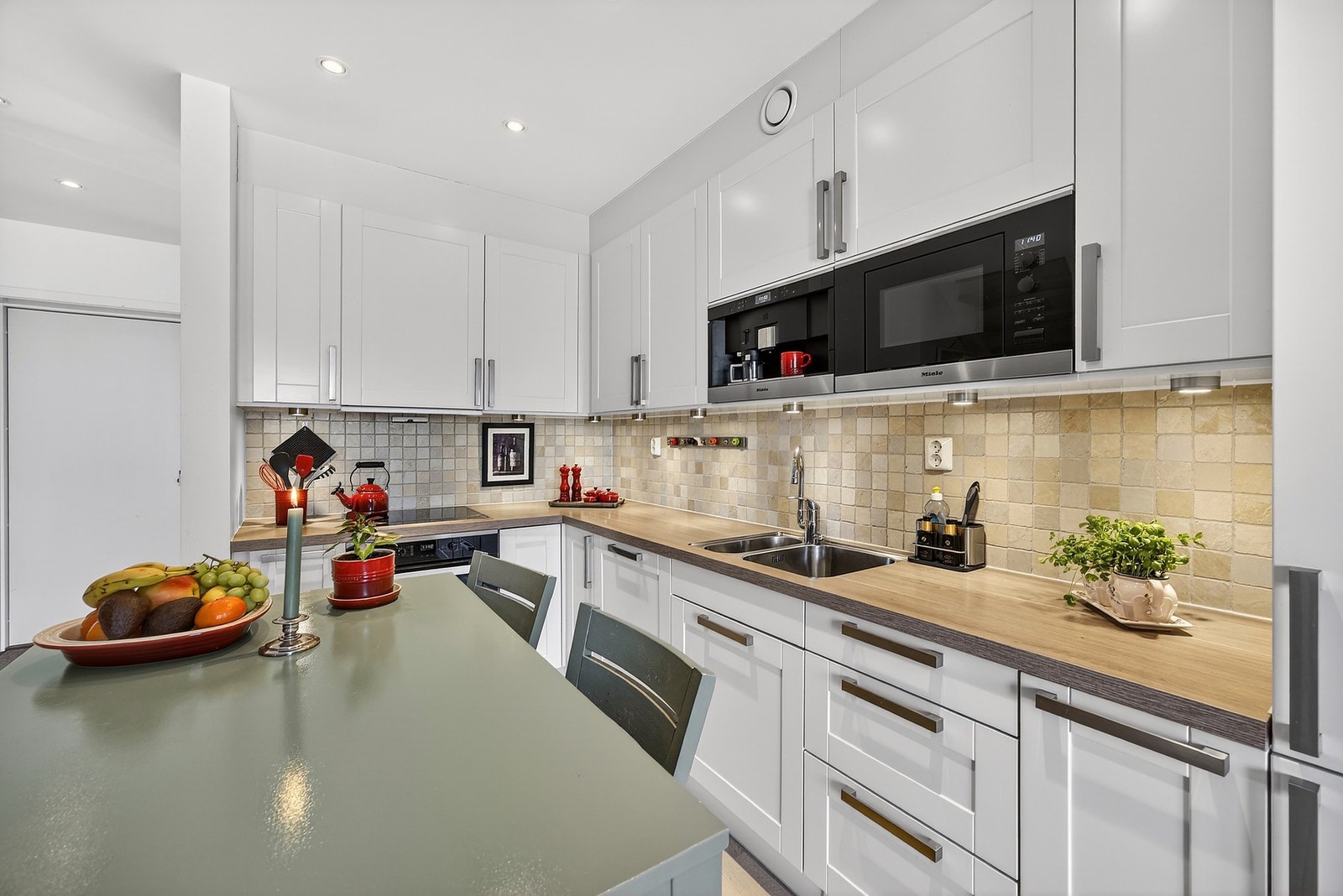 Av integrerte hvitevarer medfølger kjøl/frys, platetopp, oppvaskmaskin, stekeovn, kaffemaskin og mikrobølgeovn. Galleribilde