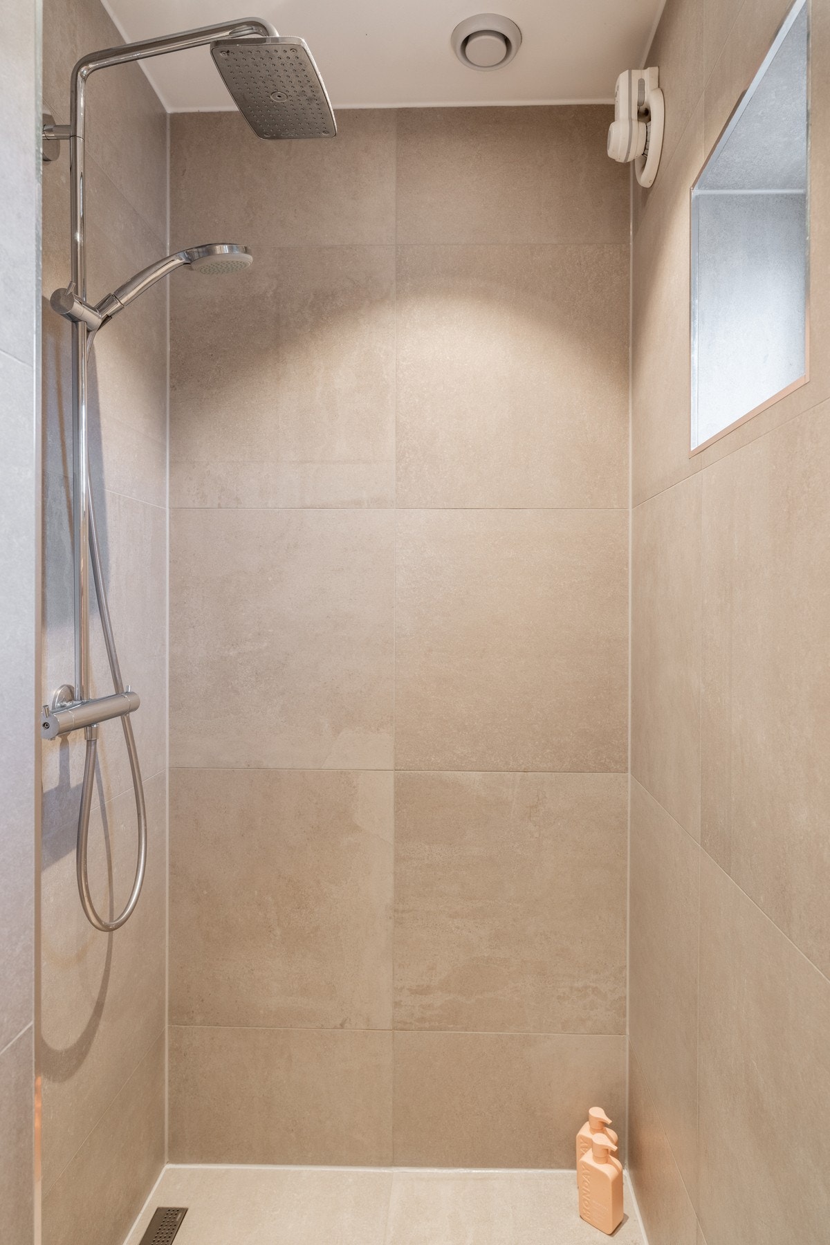 Romslig dusjnisje med vegghengt dusjgarnityr med regnfallsdusj og hånddusj. Galleribilde