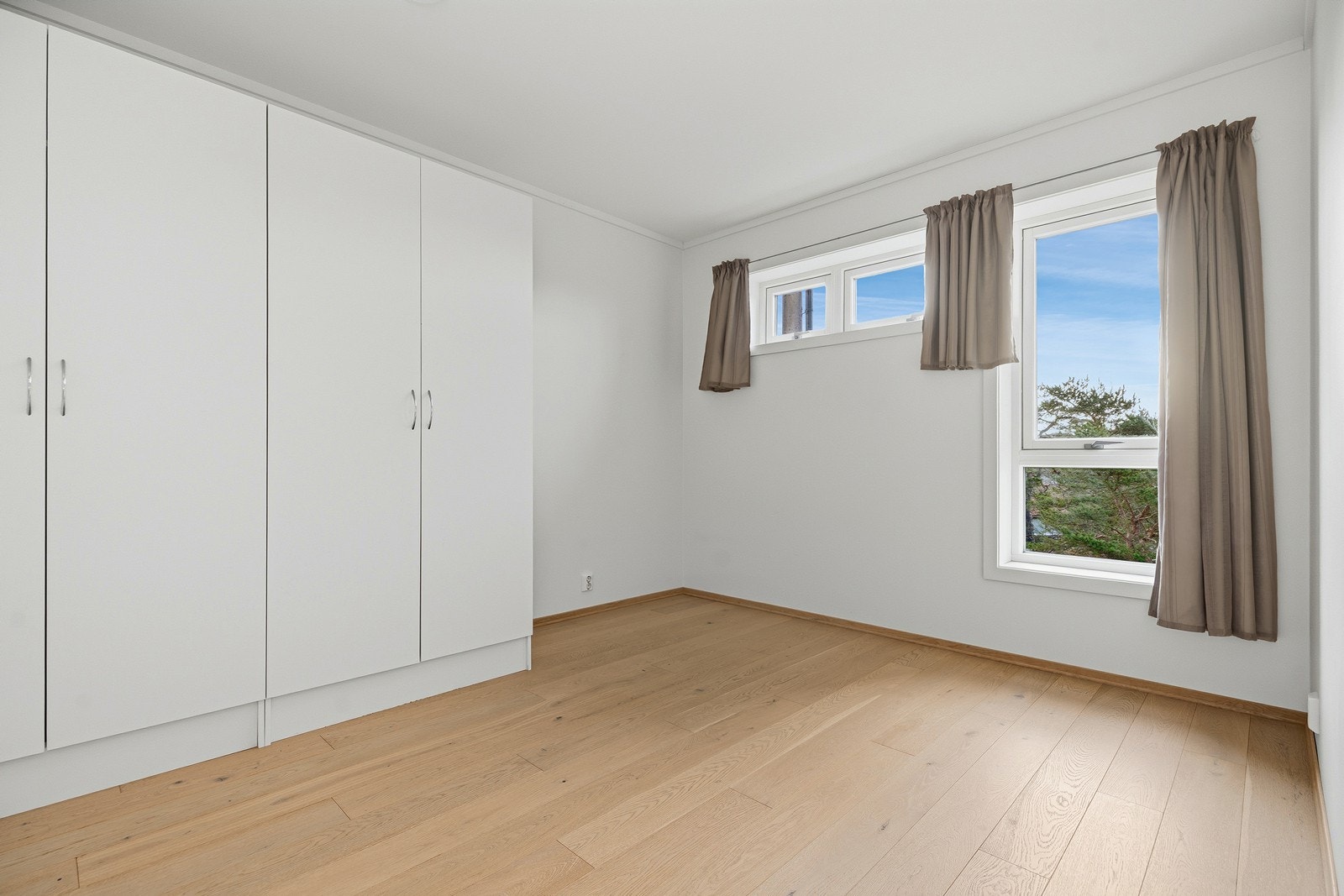 Romslig hovedsoverom med plass til seng, nattbord og garderobeskap Galleribilde