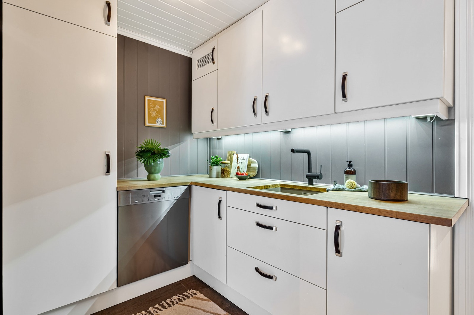 Kjøkkenet har frittstående oppvaskmaskin og kjøleskap med fryser. Galleribilde