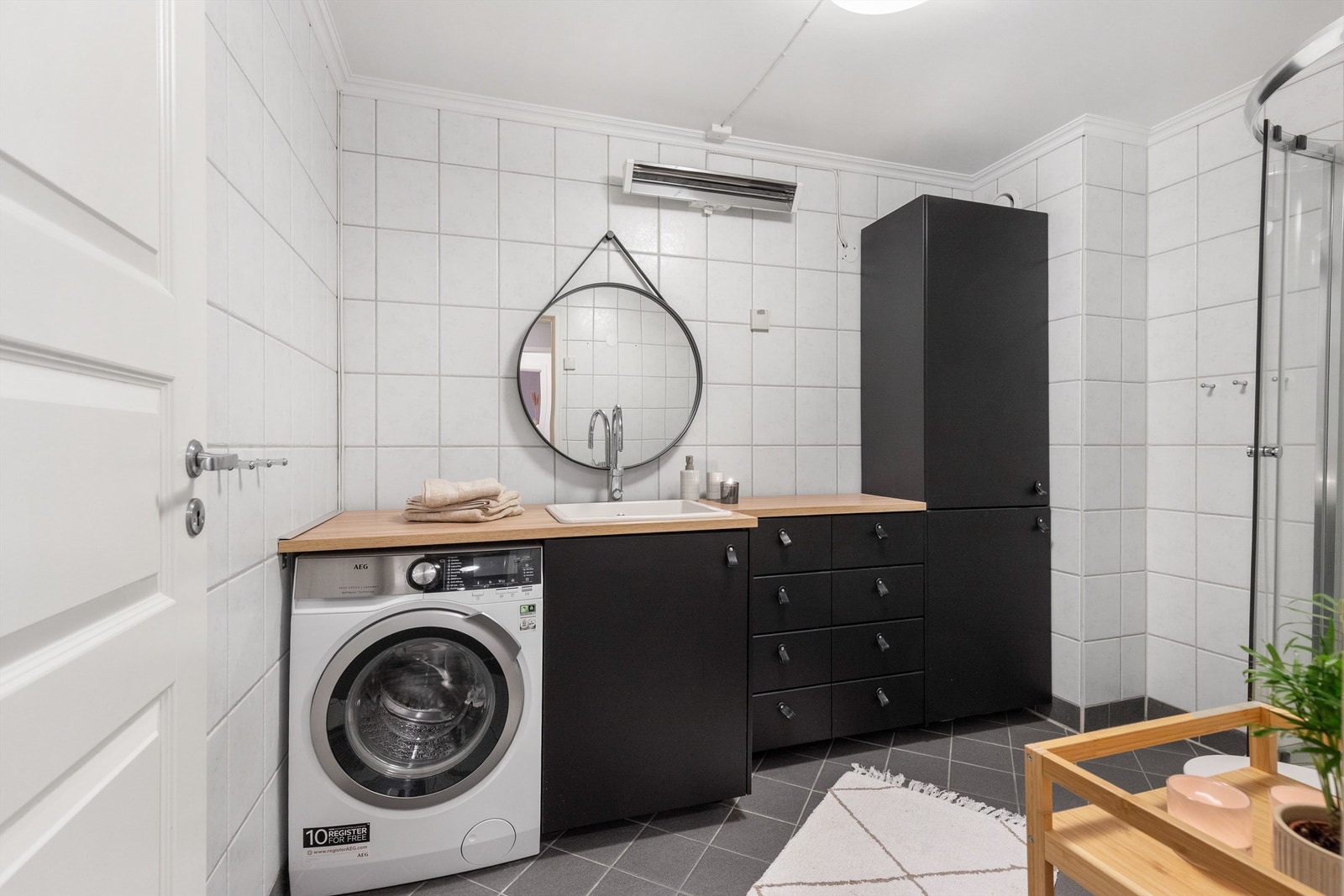 Funksjonelt og pent bad, flislagt på gulv og vegger. Det er plass og opplegg for vaskemaskin i nisje i innredningen Galleribilde