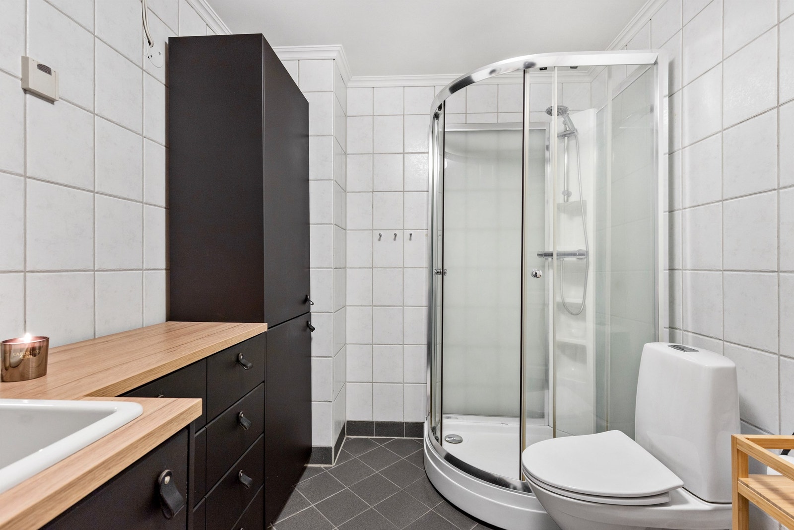 Badet er innredet med servant, toalett og et praktisk dusjkabinett. Galleribilde