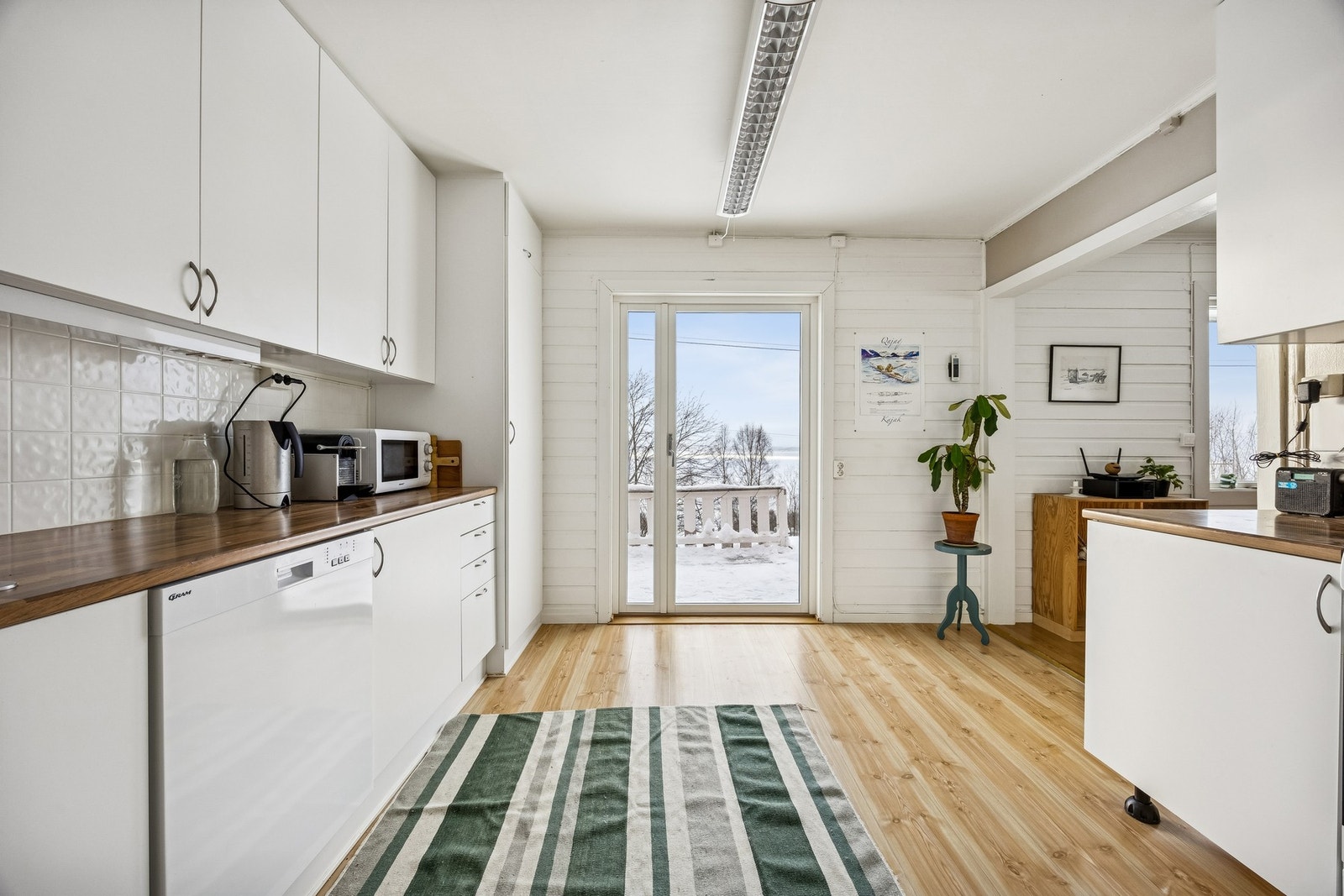 Kjøkkenet har innredning med glatte fronter og laminert benkeplate Galleribilde