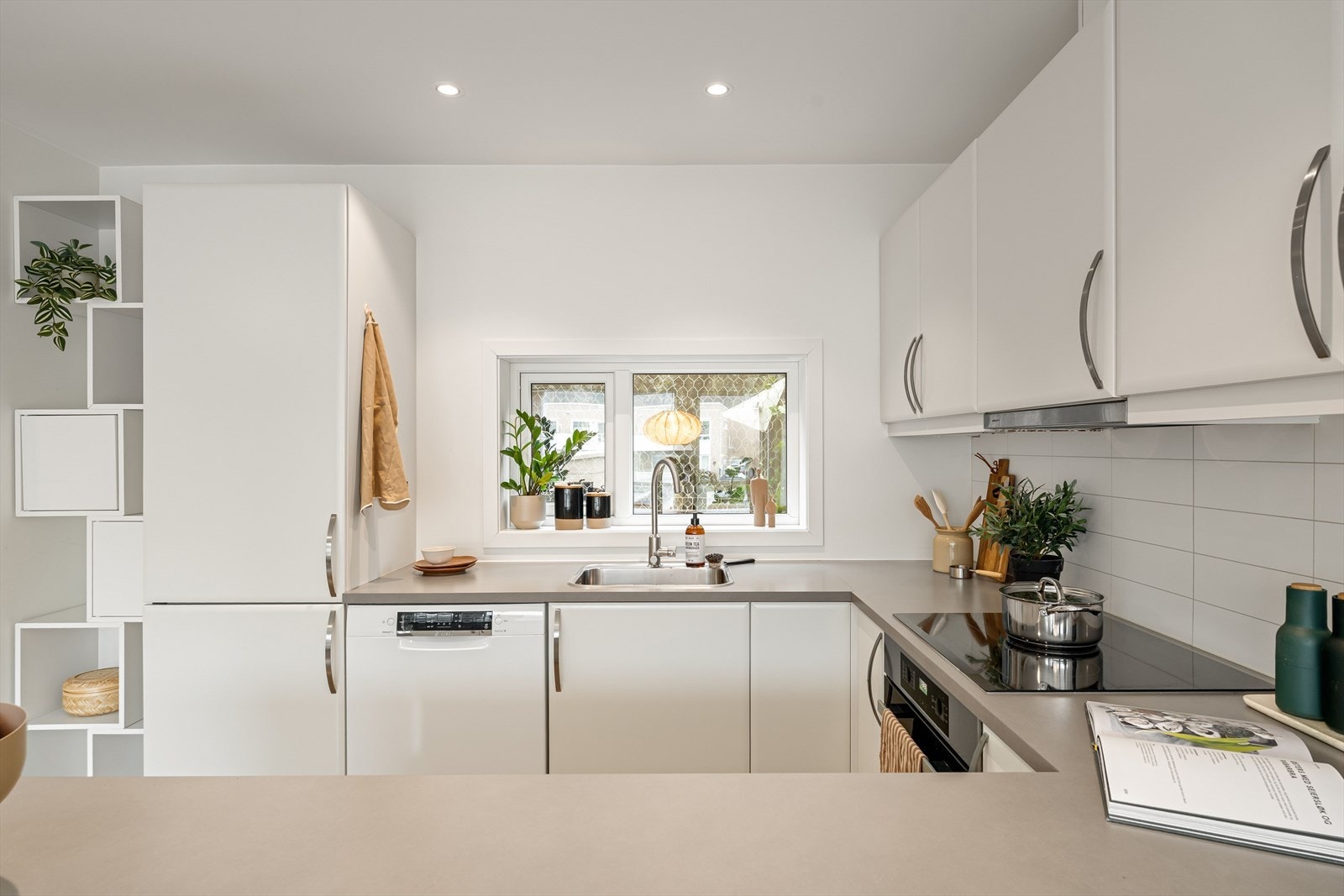 Laminat benkeplate med nedfelt stålvask og ventilator over koketopp. Galleribilde