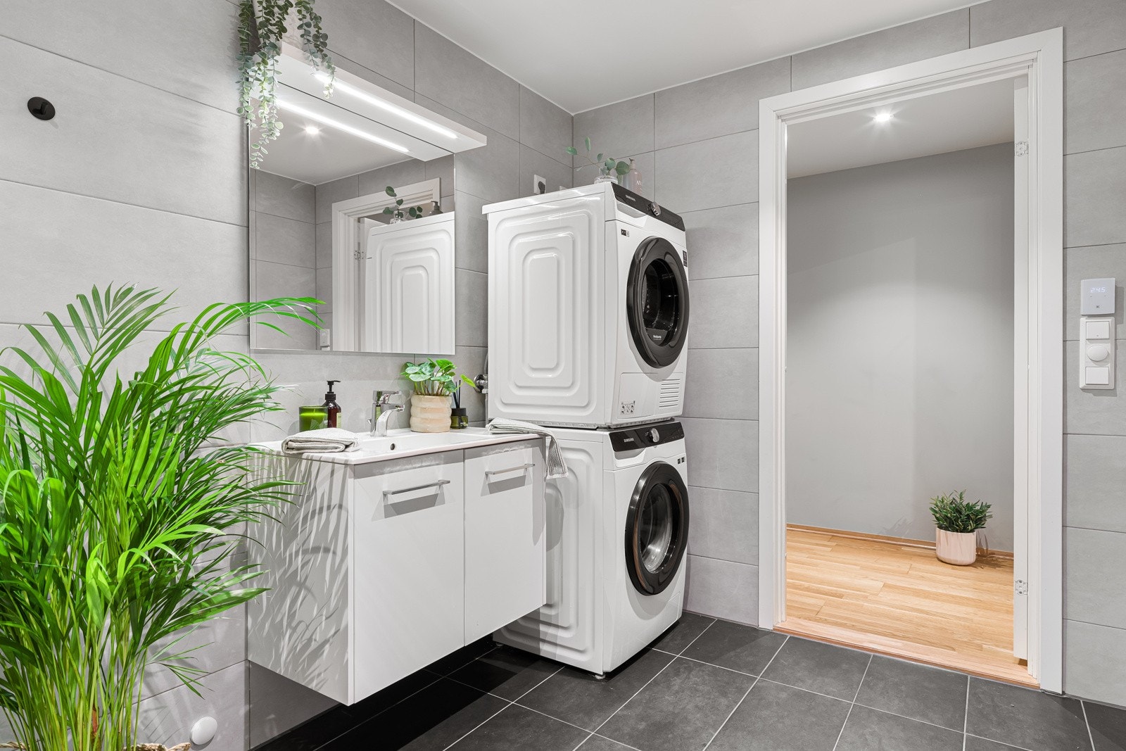 Videre er rommet utstyrt med vegghengt toalett, dusjdører og opplegg til vaskemaskin. Galleribilde