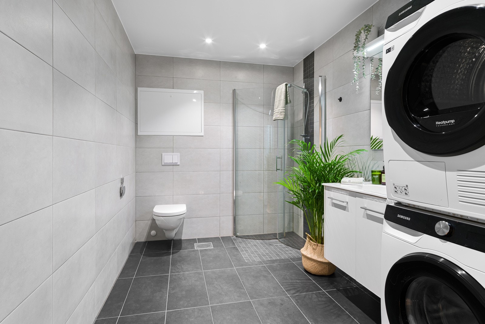 Badet har fliser på både gulv og vegger, samt gulvvarme. Badet er innredet med servant på skapseksjon og speil. Galleribilde