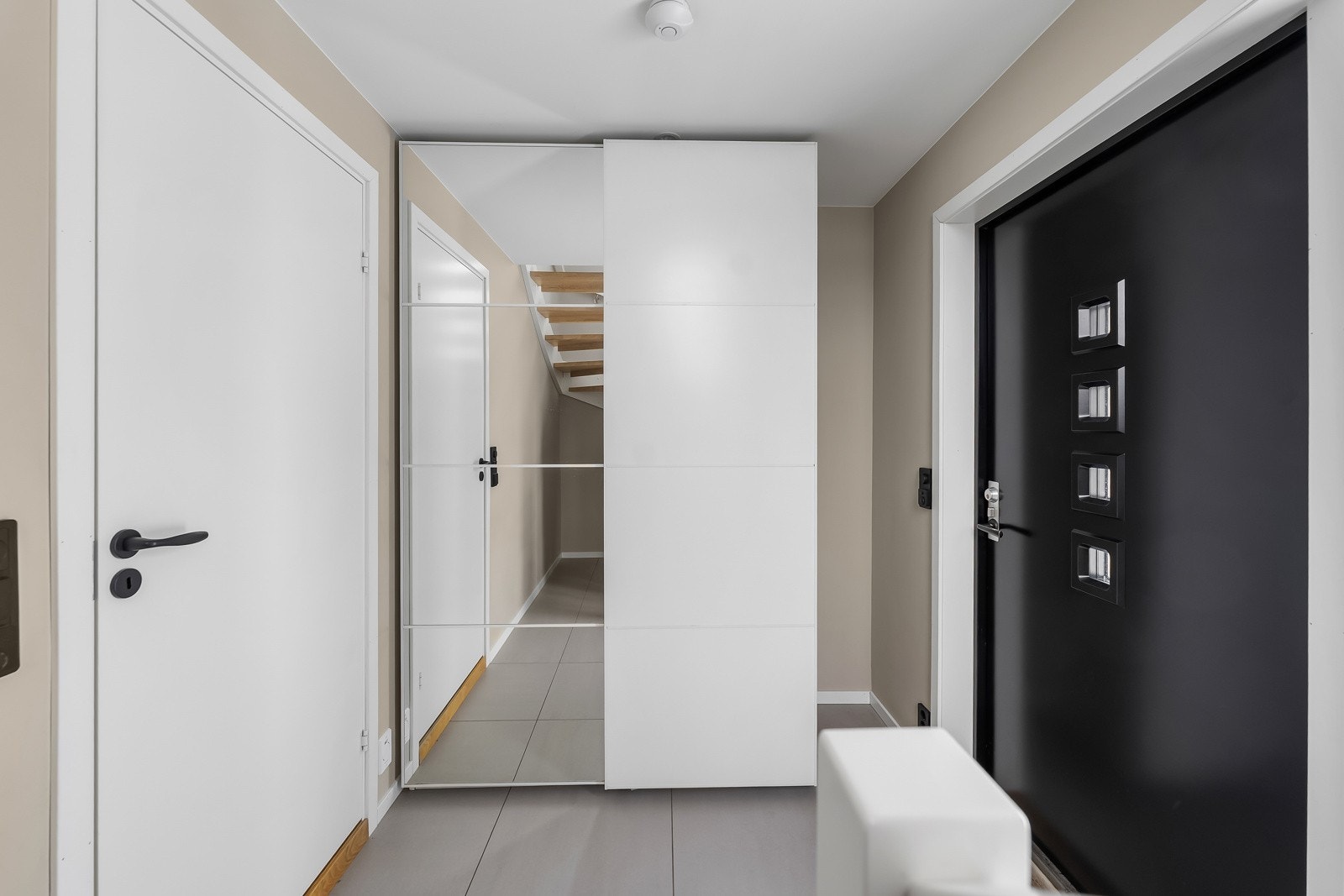 Entreen har delikate storformatfliser på gulv og malte slette veggflater, som gir et godt førsteinntrykk av boligen. Galleribilde