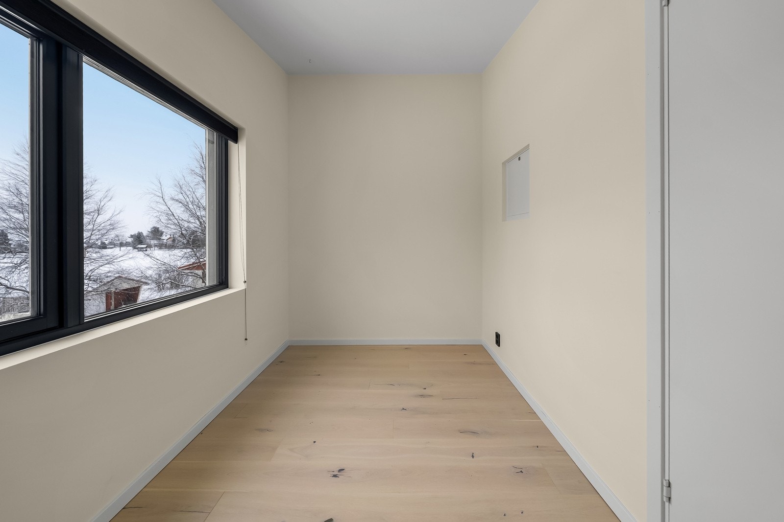 Soverom 2 fremstår som et koselig soverom med malte slette veggflater, lyspigmentert enstavs parkett på gulv og store vindusflater som slipper inn rikelig med lys Galleribilde