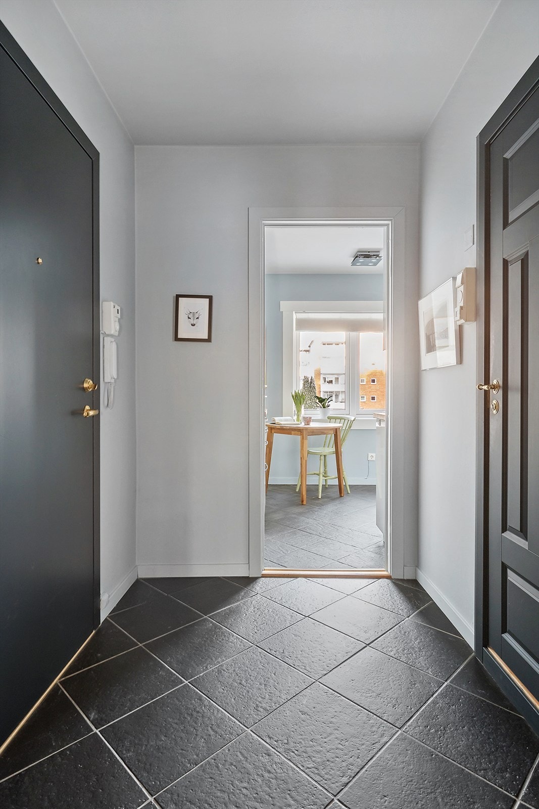 Innbydende entré med flislagt gulv og adkomst videre inn i boligen. Galleribilde