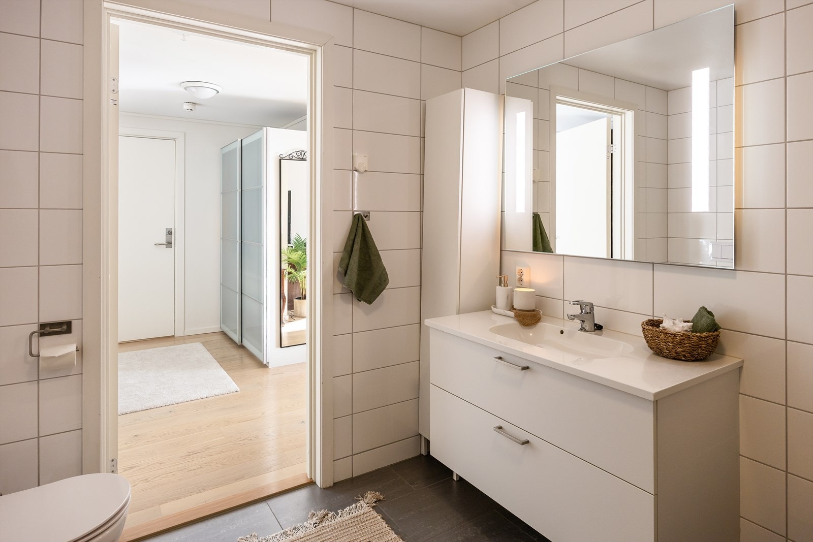 Badet er utstyrt med vegghengt toalett, innfellbare dusjvegger i glass, innredning med servant og opplegg for oppvaskmaskin. Galleribilde