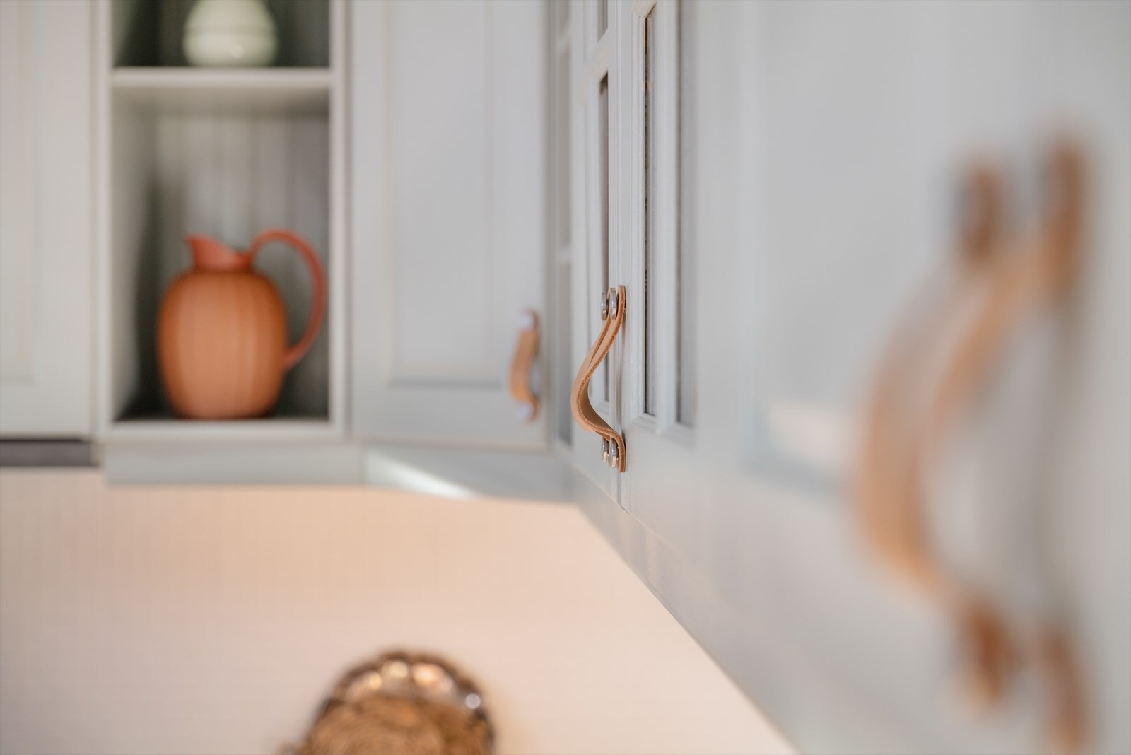 Kjøkkeninnredningen fra HTH er malt i den harmoniske mintfargen Exhale fra Jotun. Kjøkkenhåndtak i brunt lær. Galleribilde