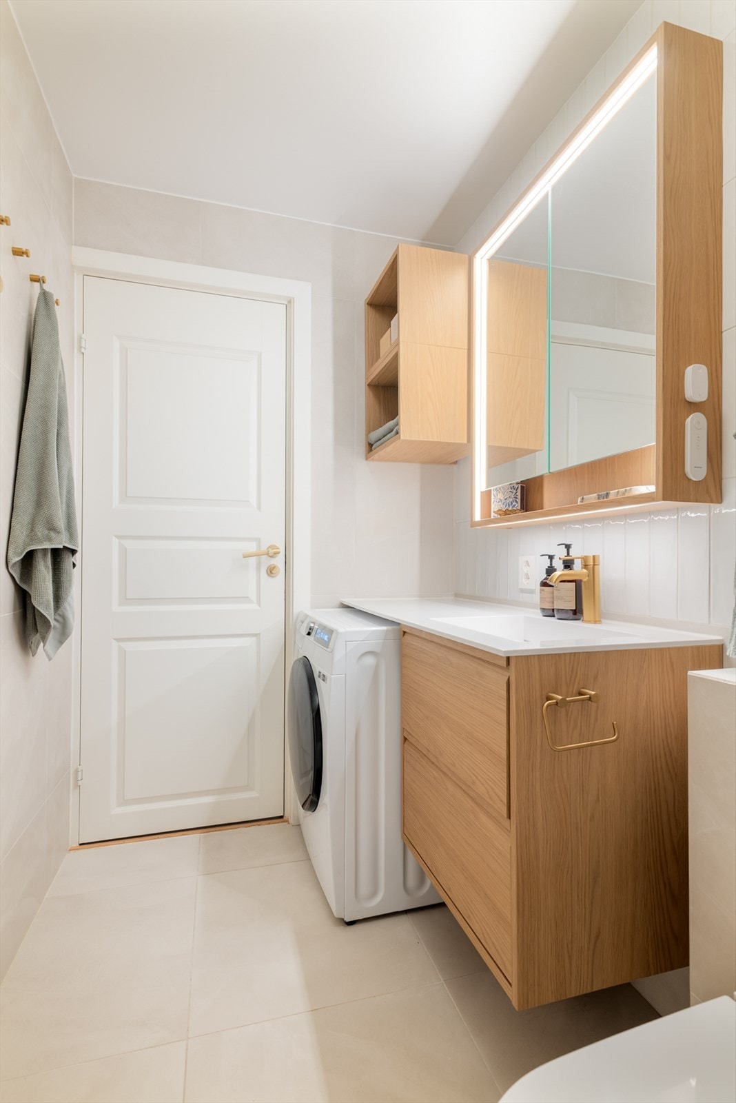 Den forlengede benkeplaten rammer inn vaskemaskinen og fungerer også godt som et stellebord. Galleribilde