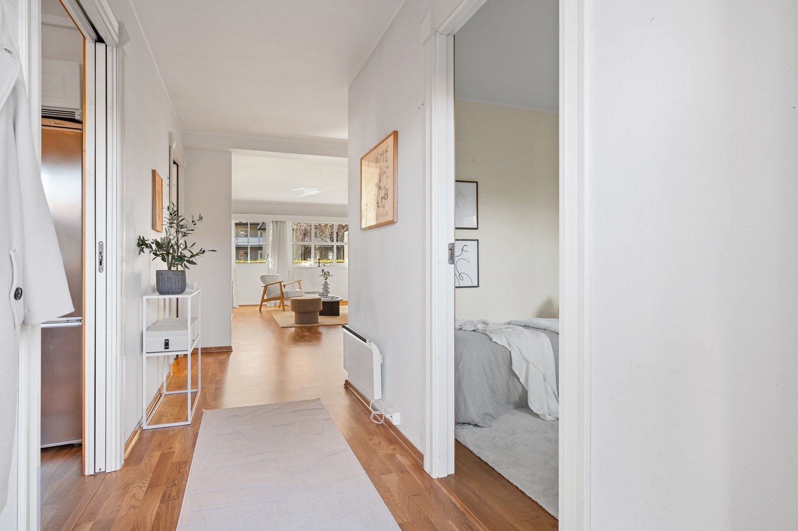 Entréen har parkett på gulv og leder deg videre inn i leilighetens oppholdsrom. - Skyvedør til kjøkkenet, på venstre side Galleribilde