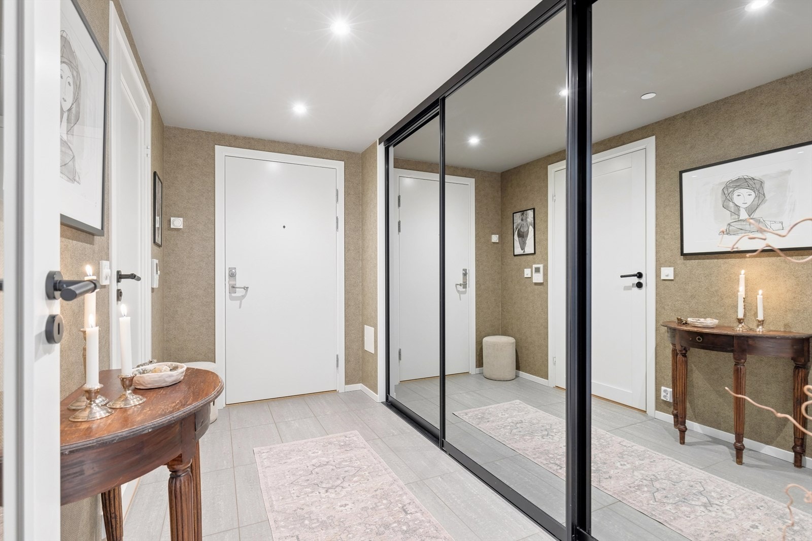 Velkommen inn! Entréen tar deg godt imot med et eksklusivt inntrykk, lekker tapet, flislagt gulv og plassbygget skyvedørsgarderobe med speilfronter. Galleribilde
