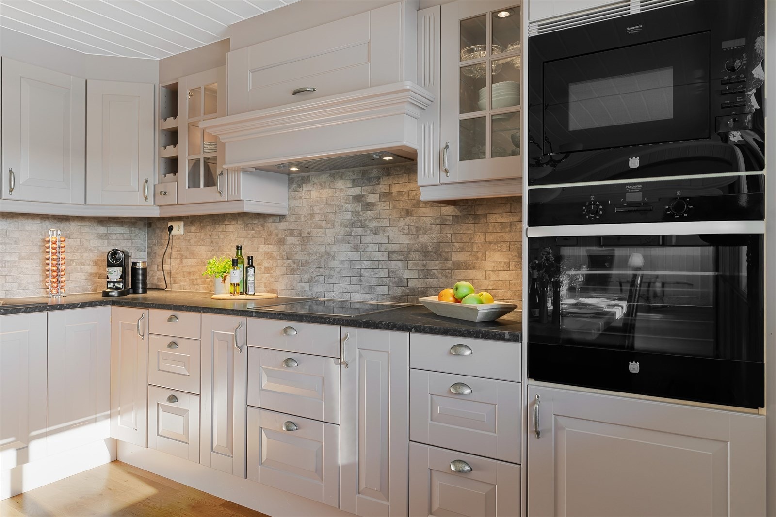 Kjøkkenet har godt med skap og benkeplass og har lekre fliser på vegg mellom benkeplate og overskap. Galleribilde