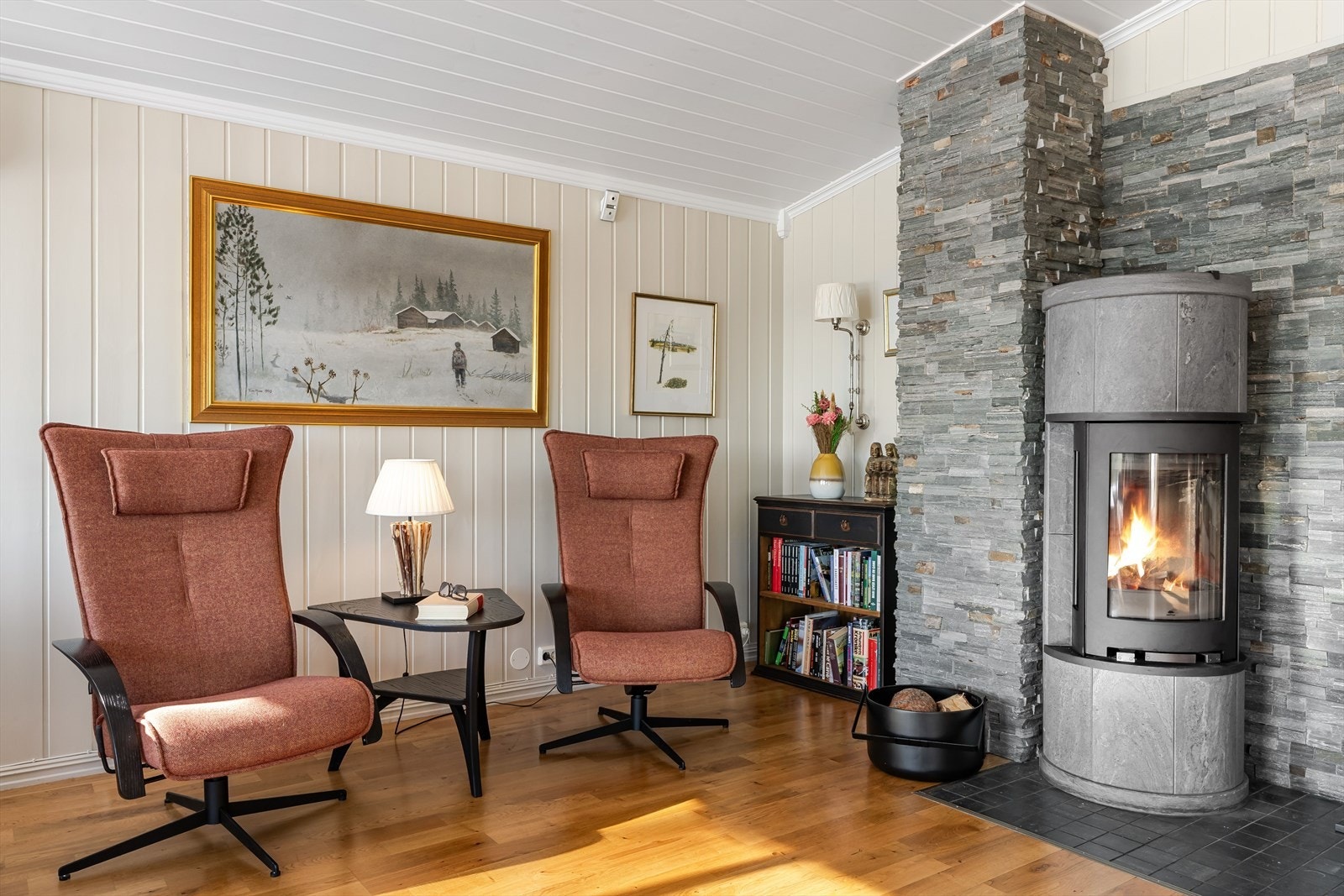 Hytta varmes opp med en flott ovn og det er også varmepumpe i stuen. Galleribilde