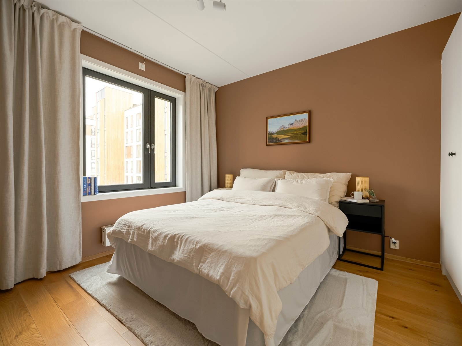 Romslig og lyst soverom som er malt i en moderne og harmonisk fargetone. Galleribilde