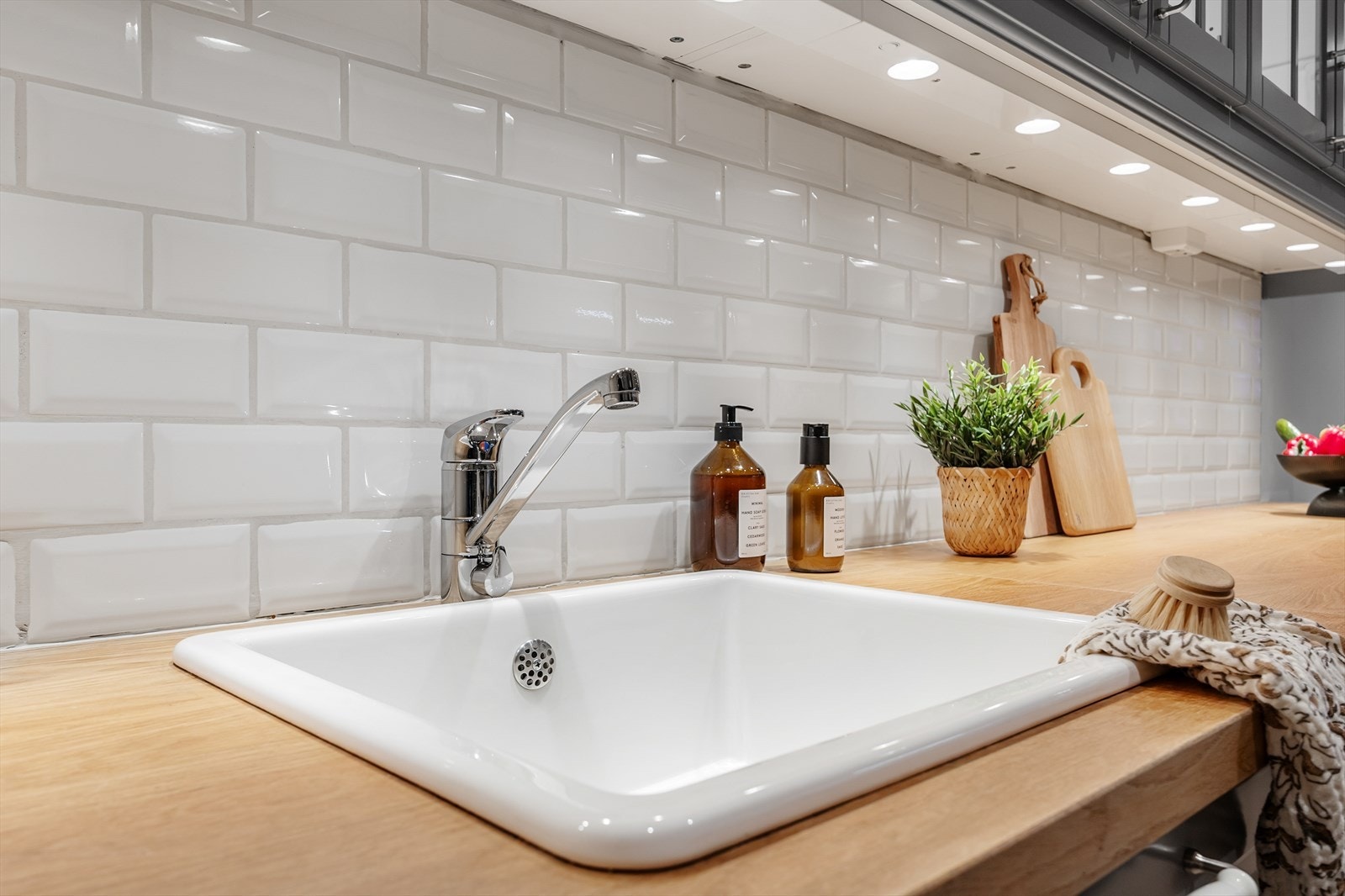 Mellom benkeplaten og overskapene er det horisontale flislagte flater som skaper et unikt preg. Galleribilde