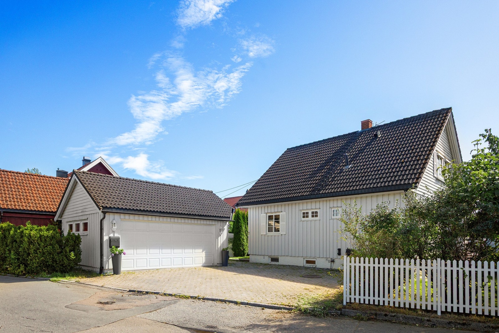 På fremsiden er det steinsatt gårdsplass og dobbelgarasje. Galleribilde