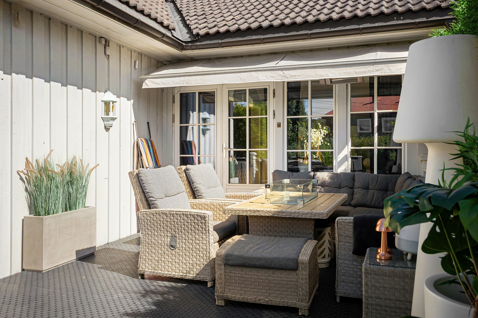 Uteplassen på 42 kvm terrasse skjermes godt av hekk på sidene og er utstyrt med en markise på den innerste delen og et jacuzzi i ytterste del. Galleribilde