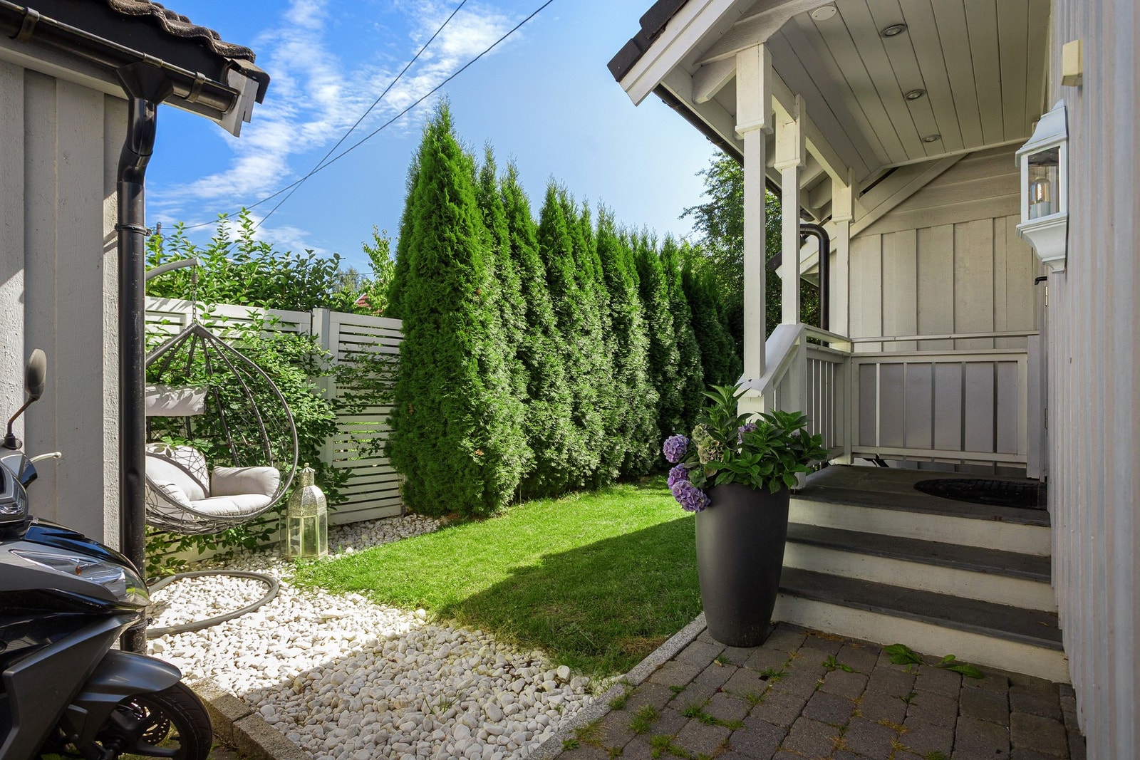 Boligen har adkomst via et overbygd inngangsparti med trapp og en pen ytterdør med glassfelt. Galleribilde